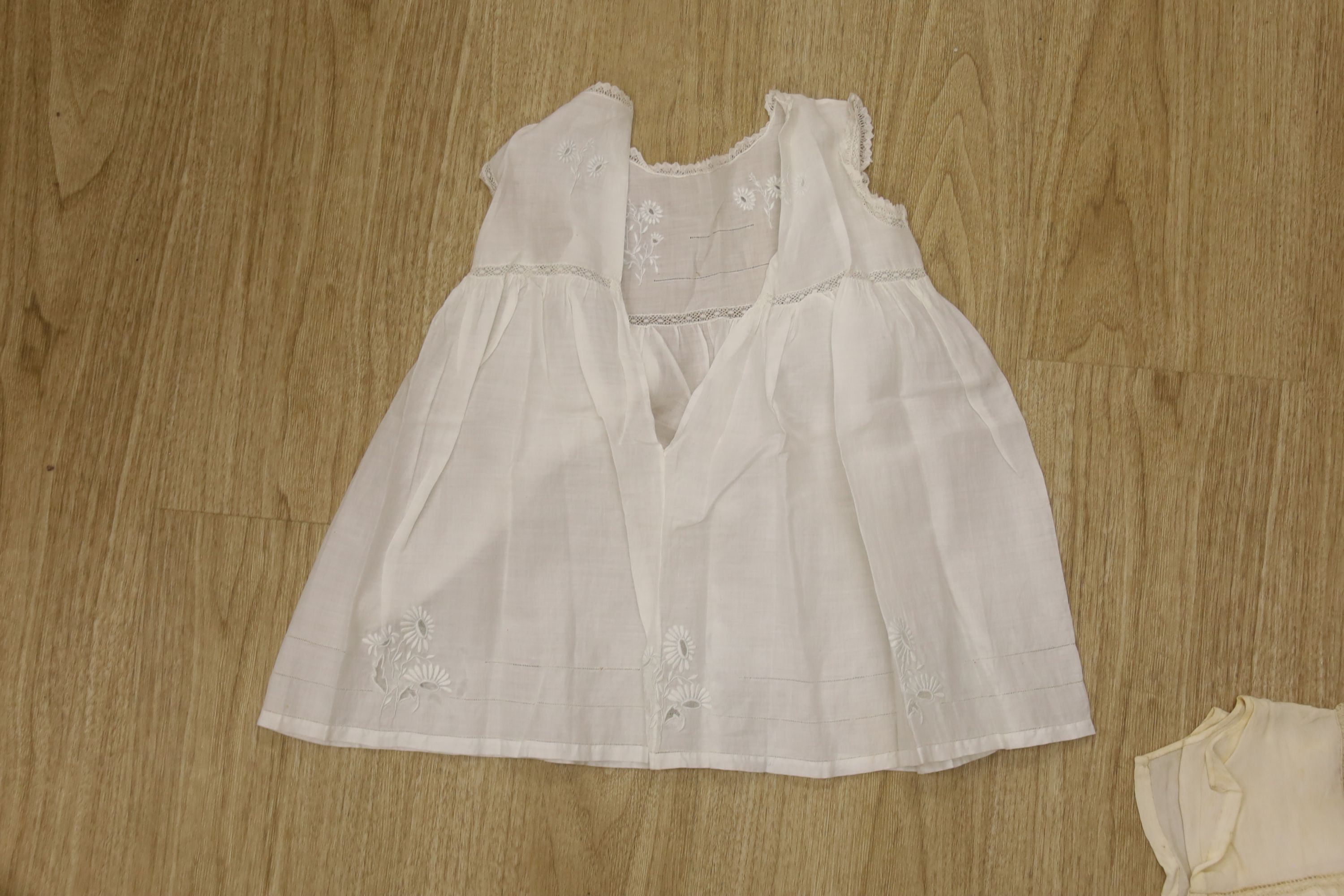 A 1920's needle run embroidered christening gown, on cream net, two whitework baby gowns and a pillow case